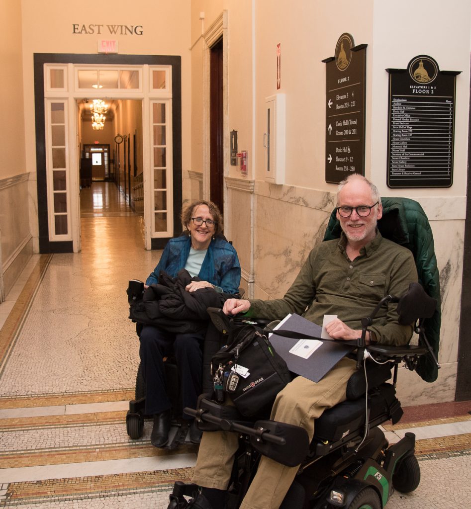 2 advocates in wheelchairs in state house hallway 2019