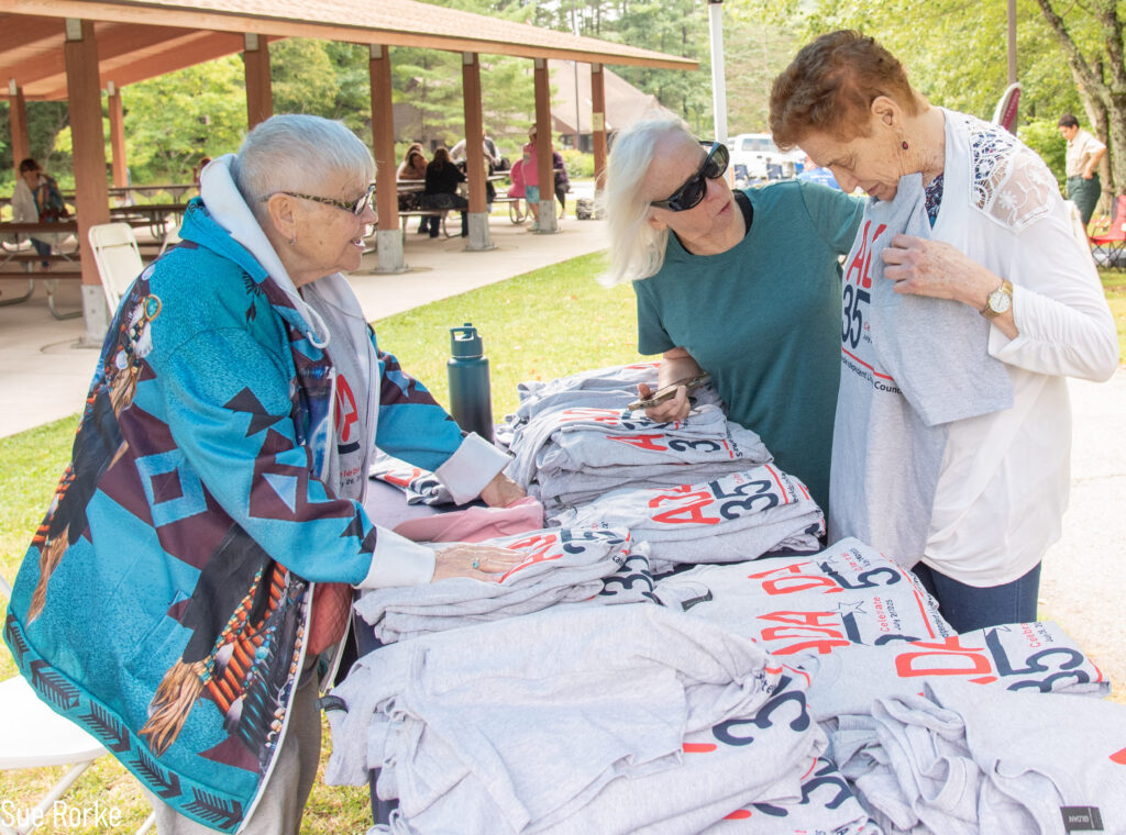 Women at the free tee shirt table.