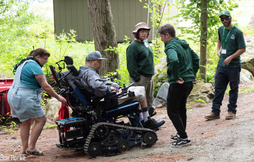 staff finishes setting up man in trail wheelchair