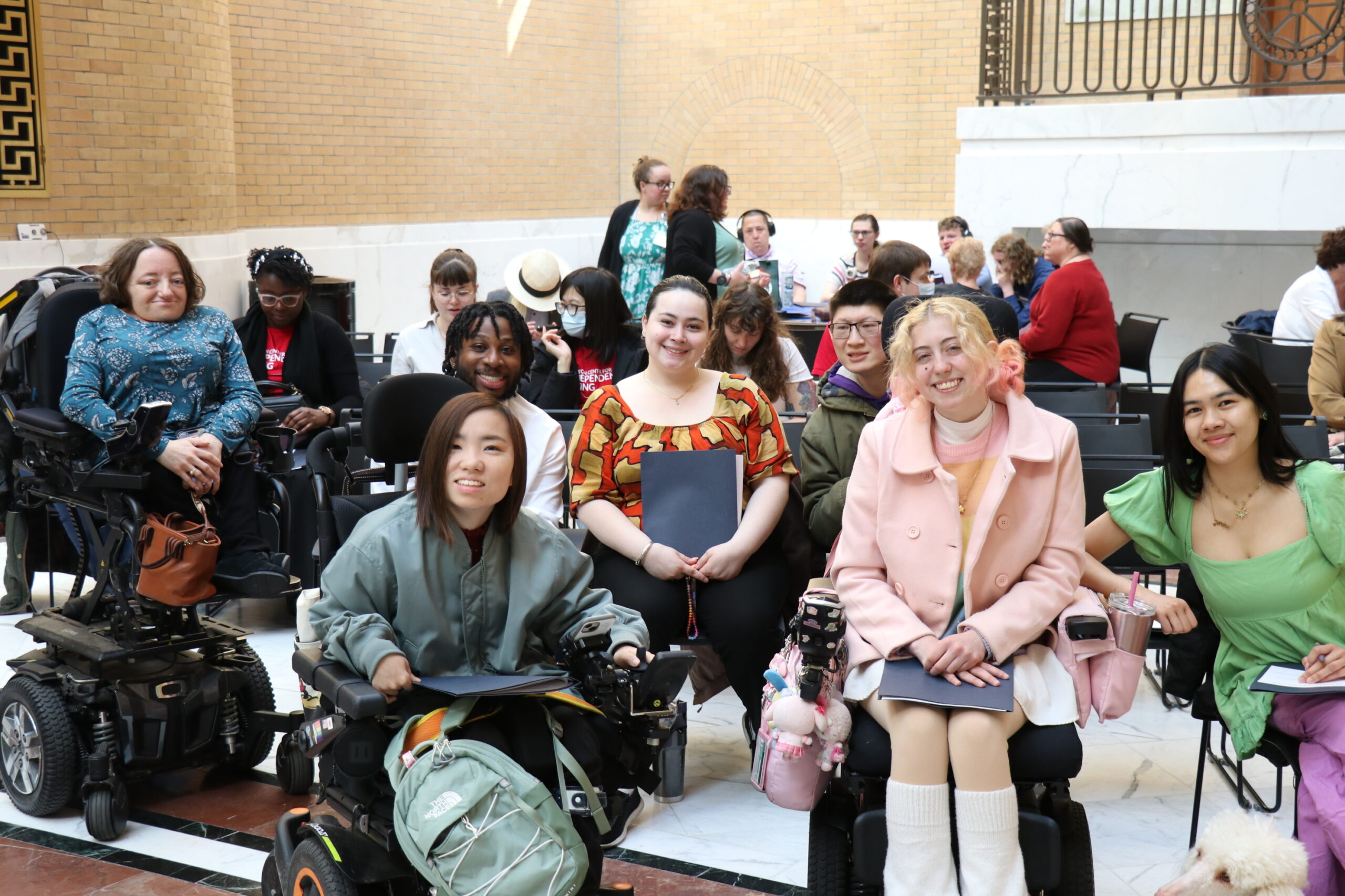 Staff and consumers at Easter Seals sitting together and smiling 