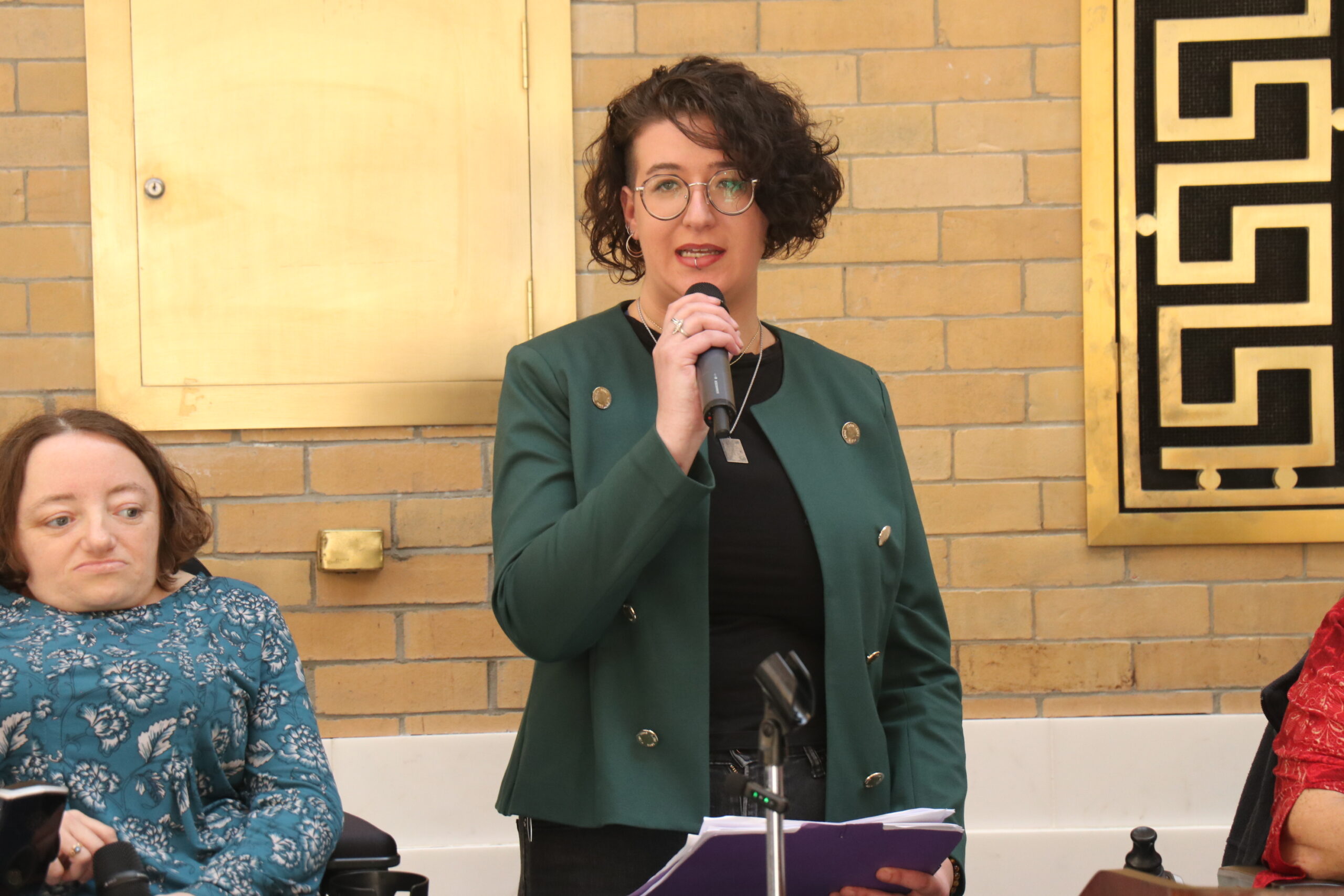 Rachael Cowan holding a microphone and speaking