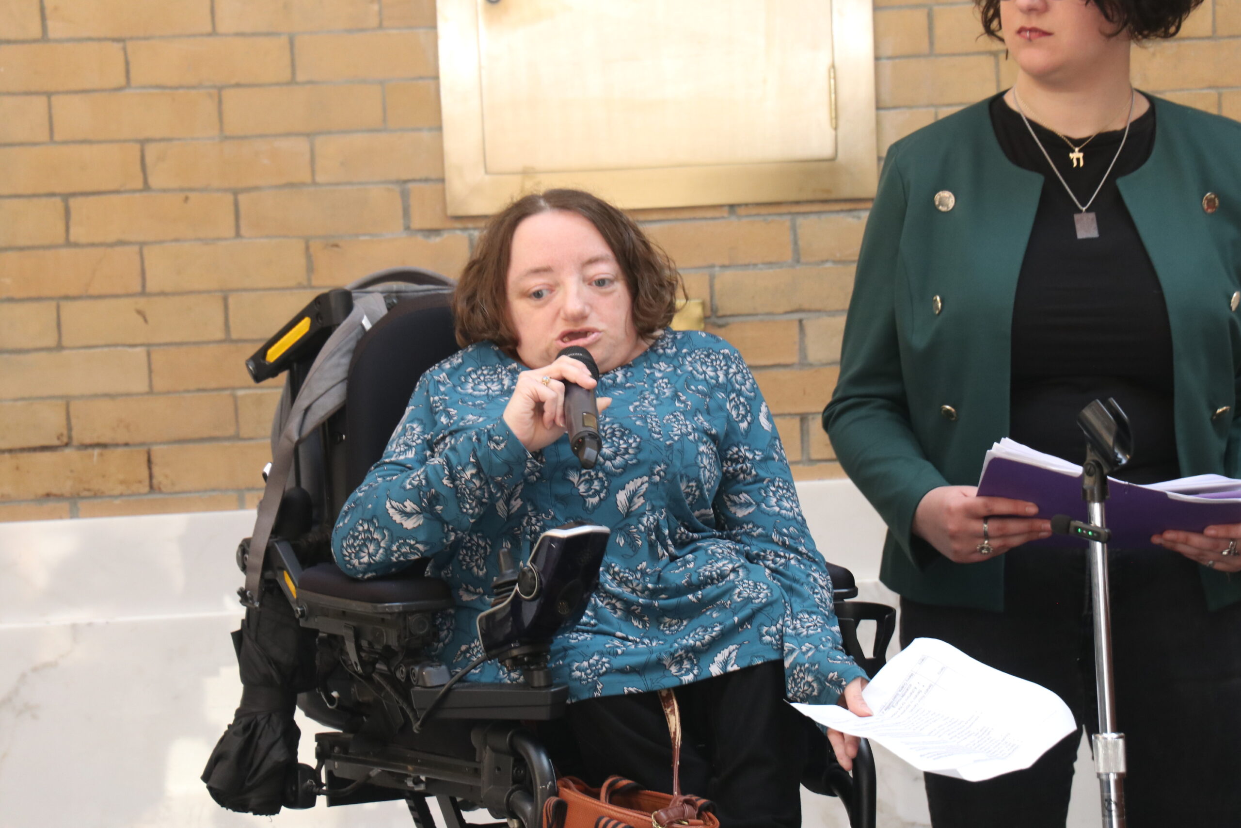 Desi Forte holding a microphone and speaking