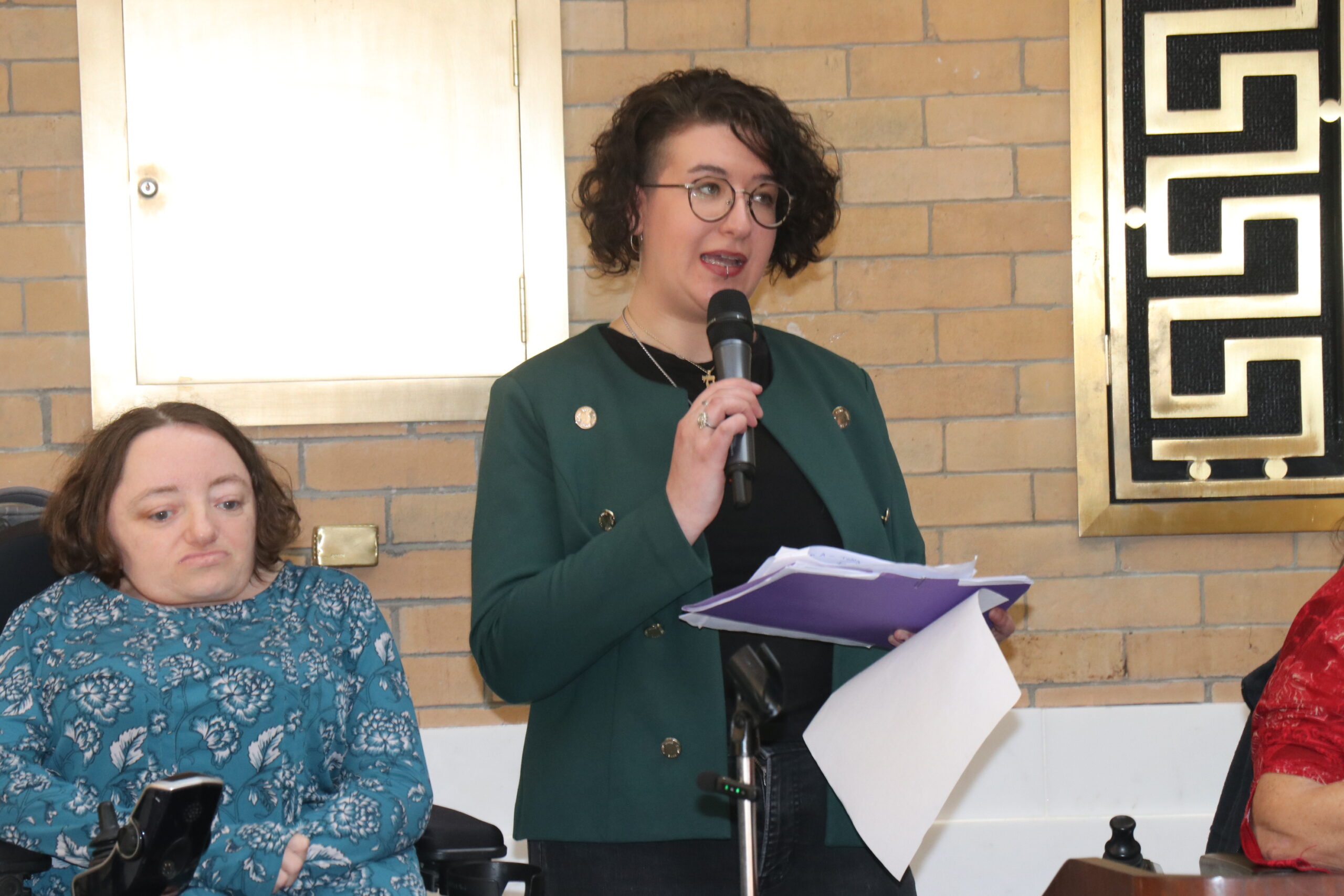 Rachael Cowan holding a microphone and speaking