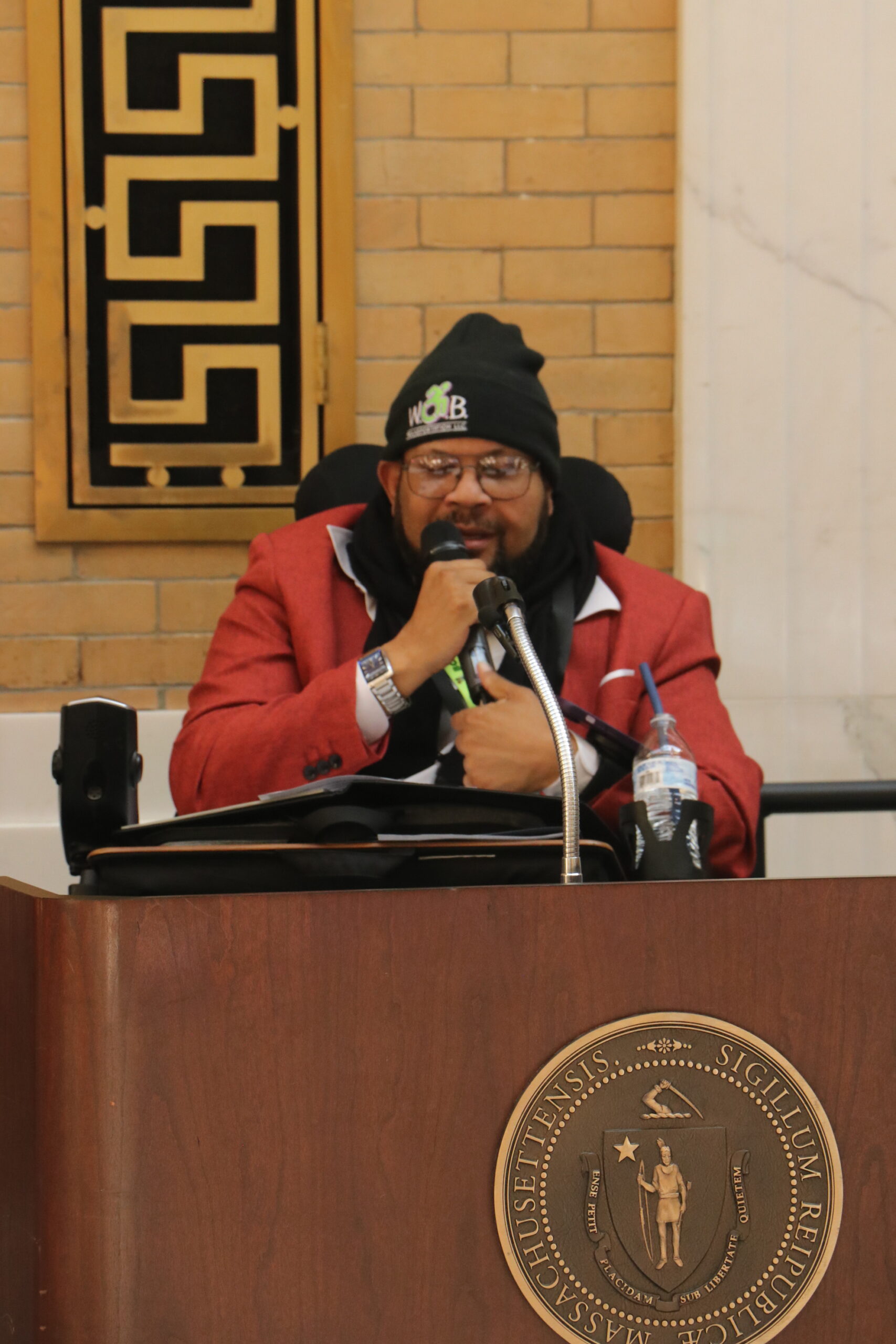 Manny Guerra speaking with a microphone at a podium