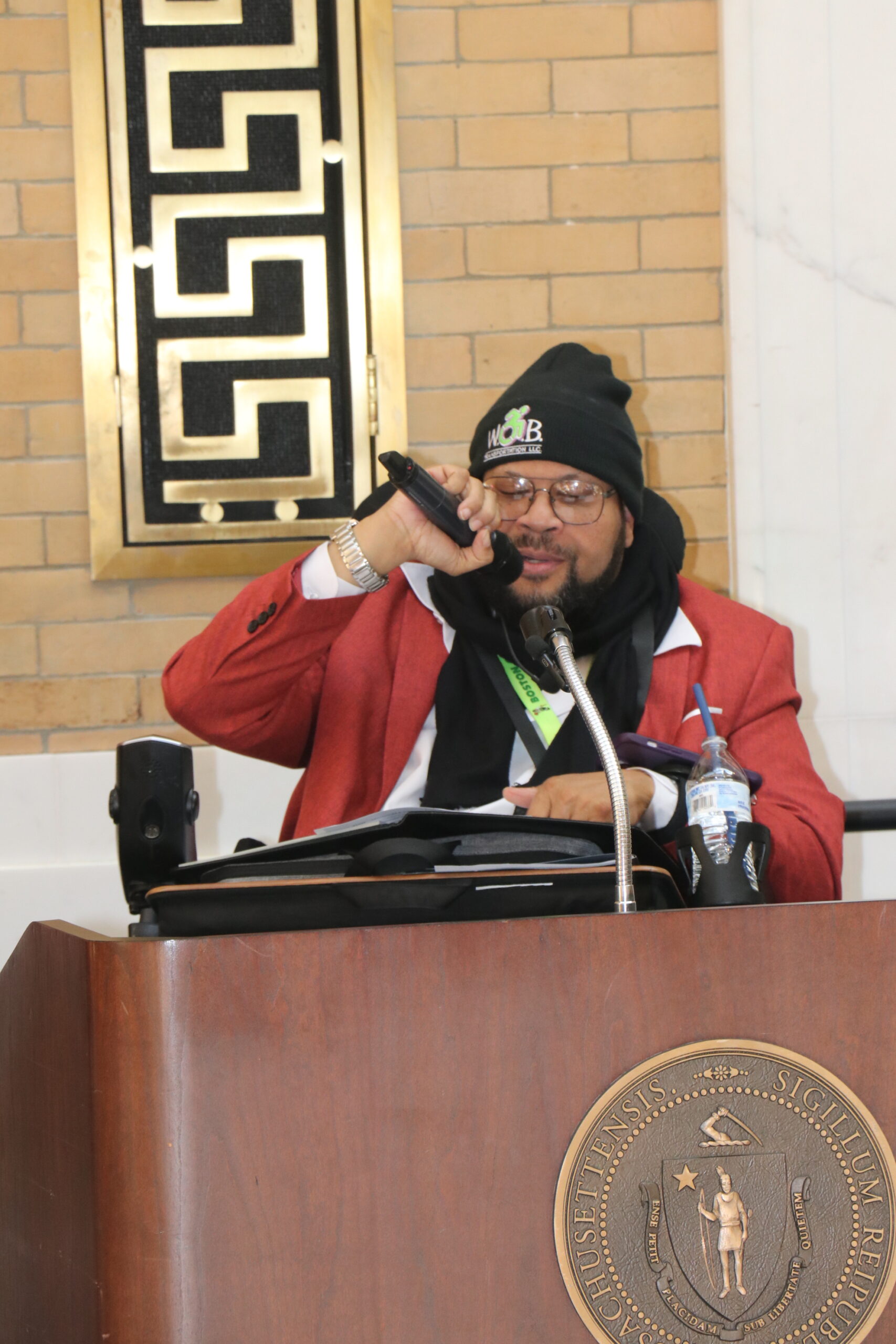 Manny Guerra speaking at a podium holding a microphone 