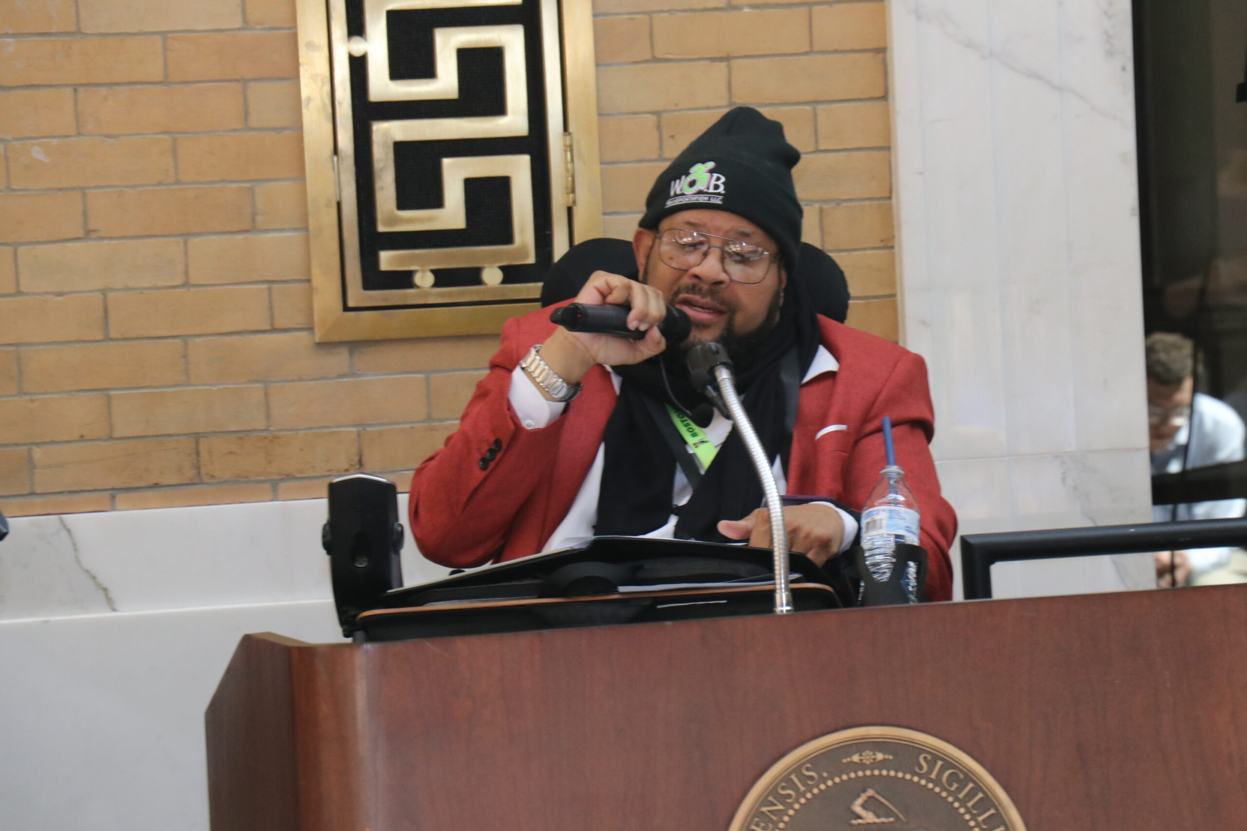 Manny Guerra speaking at a podium holding a microphone 