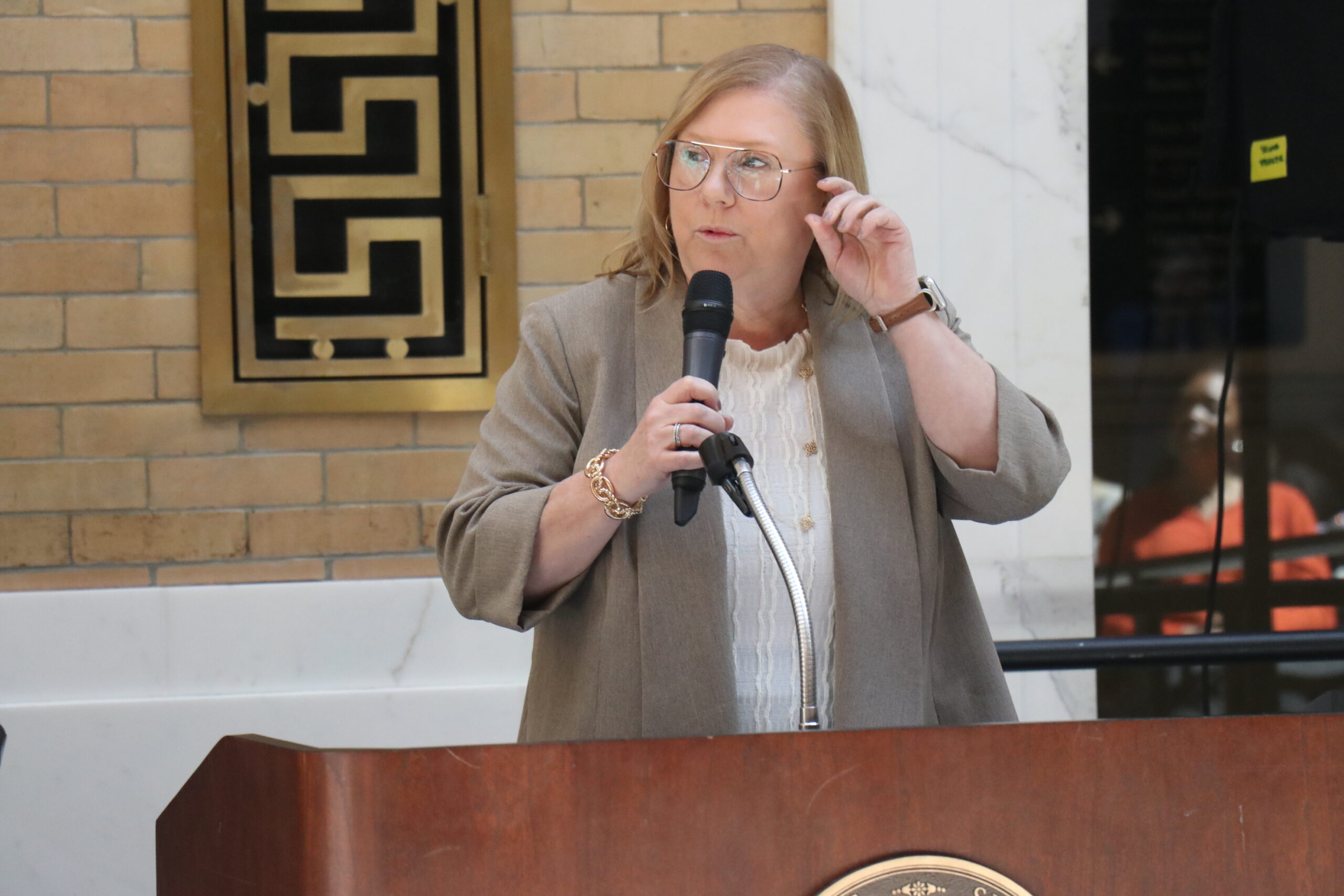 Jessica Cimini speaking with a microphone at a podium 