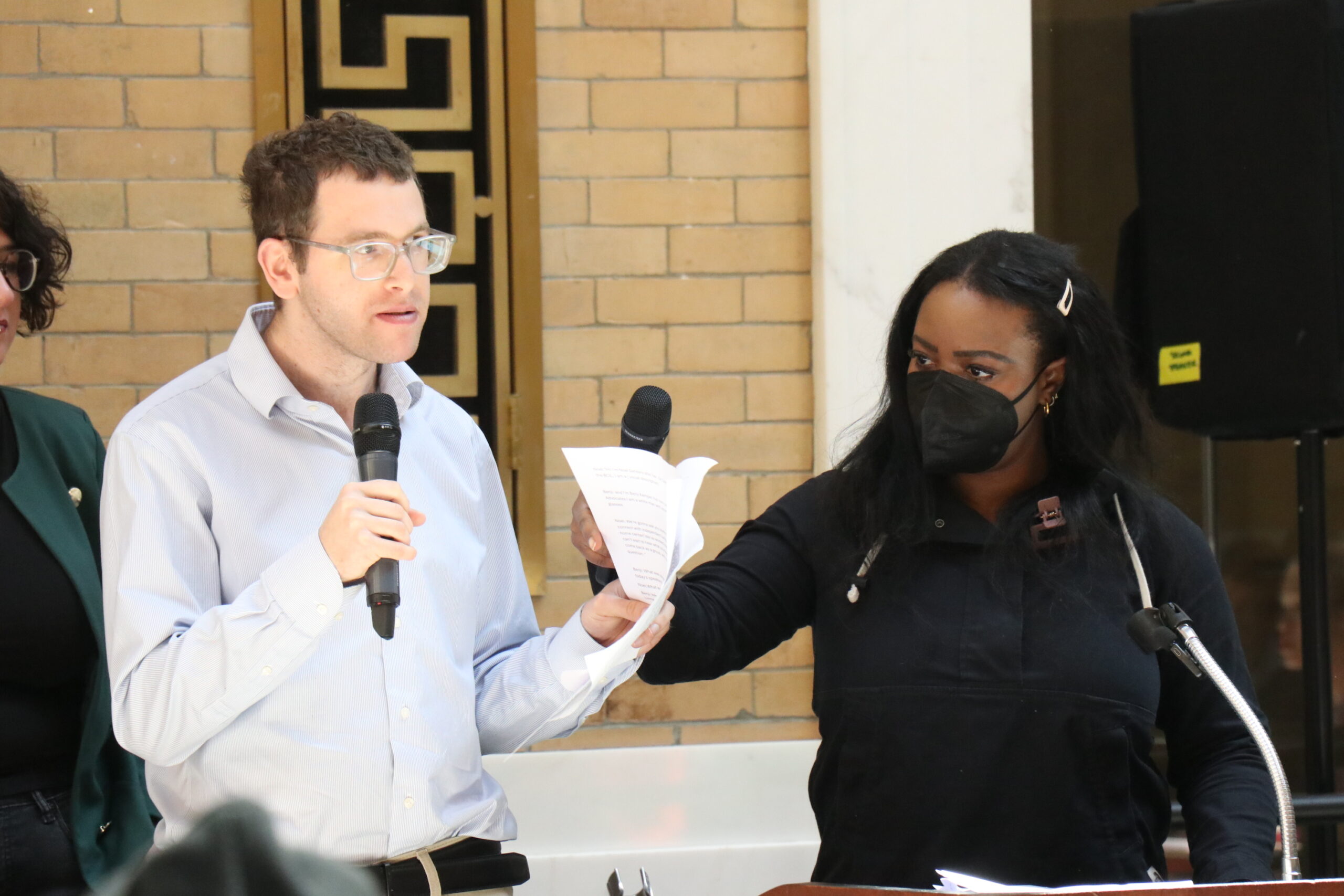 Benji Kemper and Noel Sanders holding microphones and listening