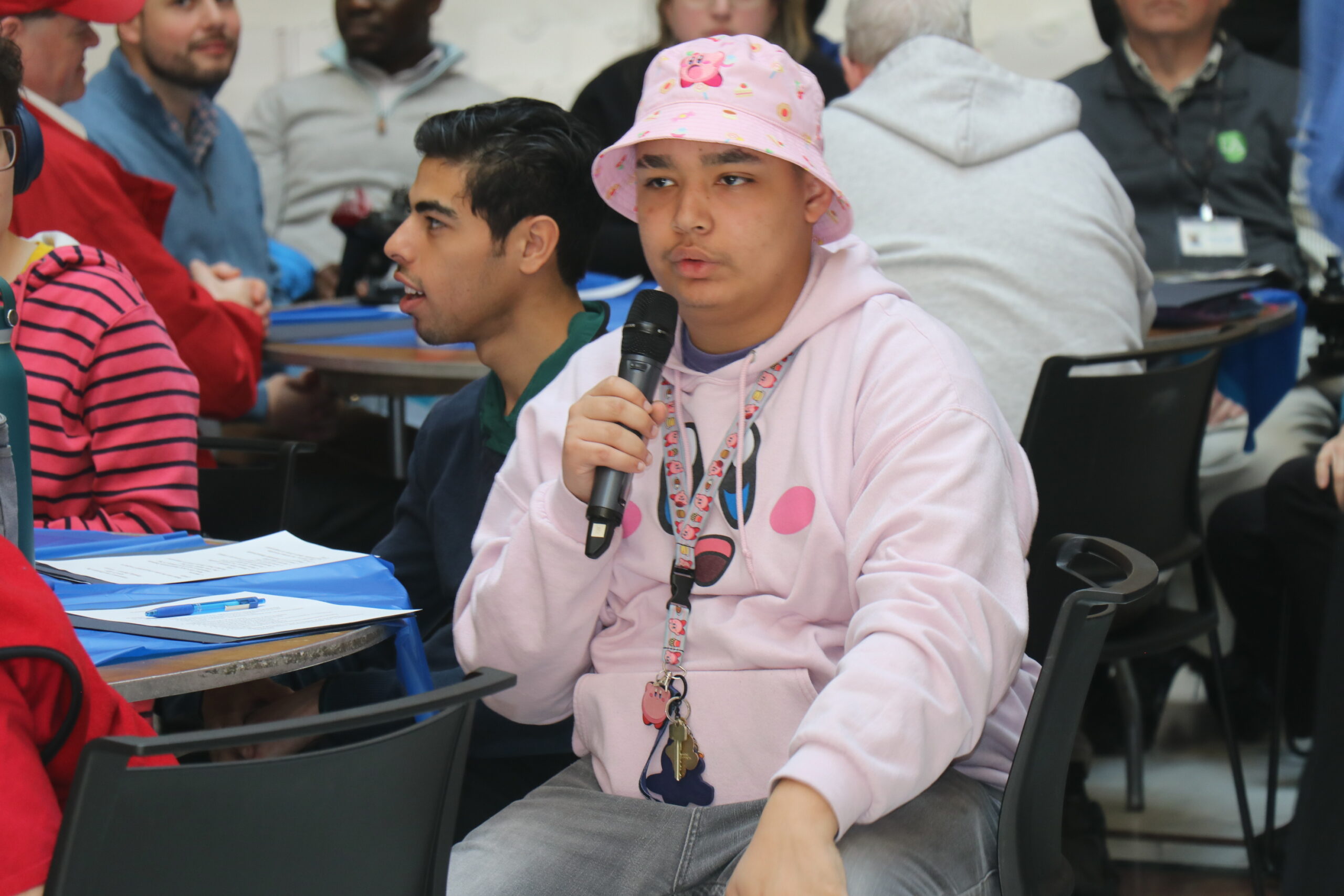 an audience member holding a microphone and speaking 