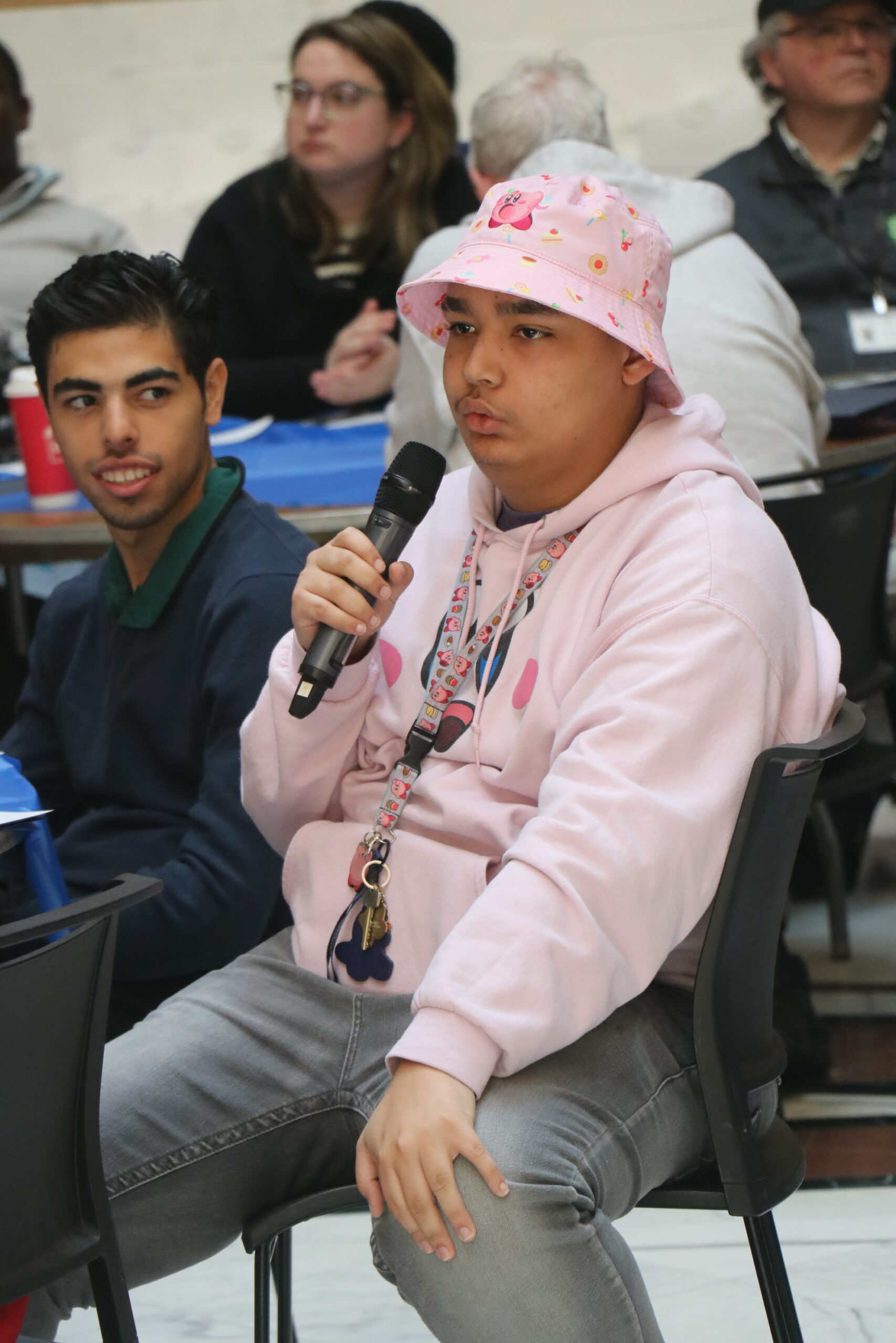 an audience member holding a microphone and speaking 