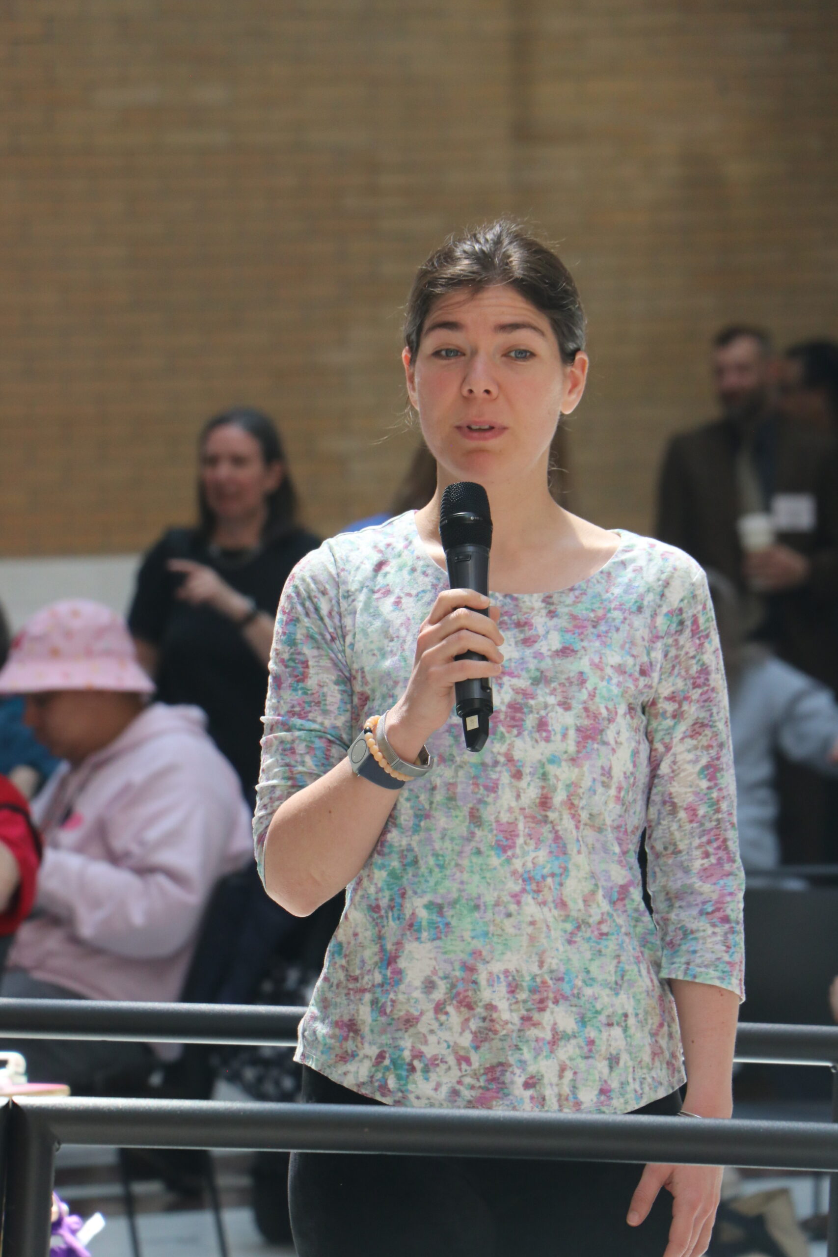 An audience member standing and speaking with a microphone 