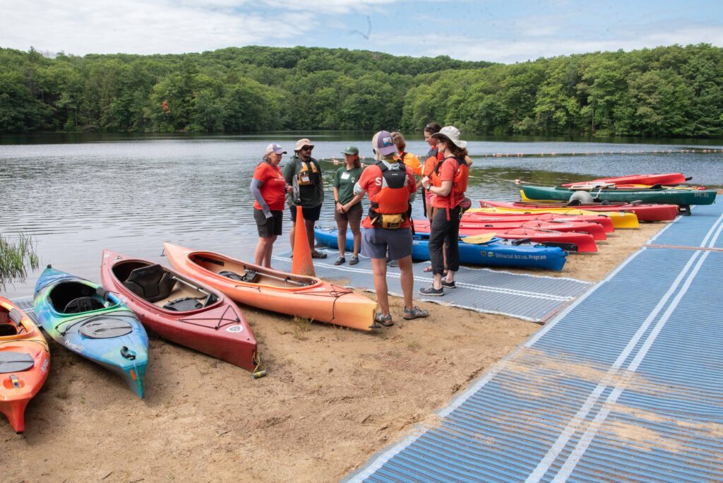 Staff getting ready on the beach with the kayaks all lined up