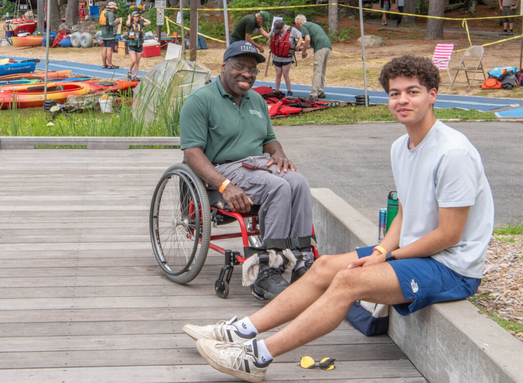 father and son smiling, father is in wheelchair