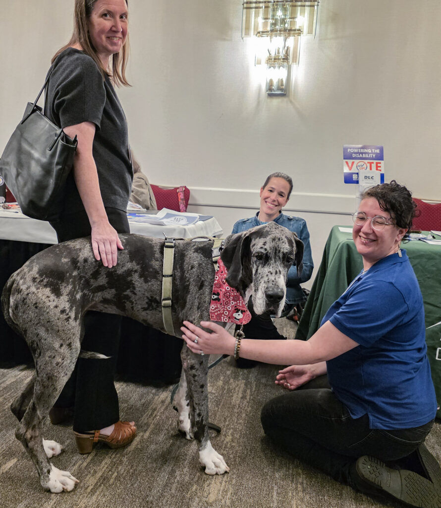 Three people smiling and a dog