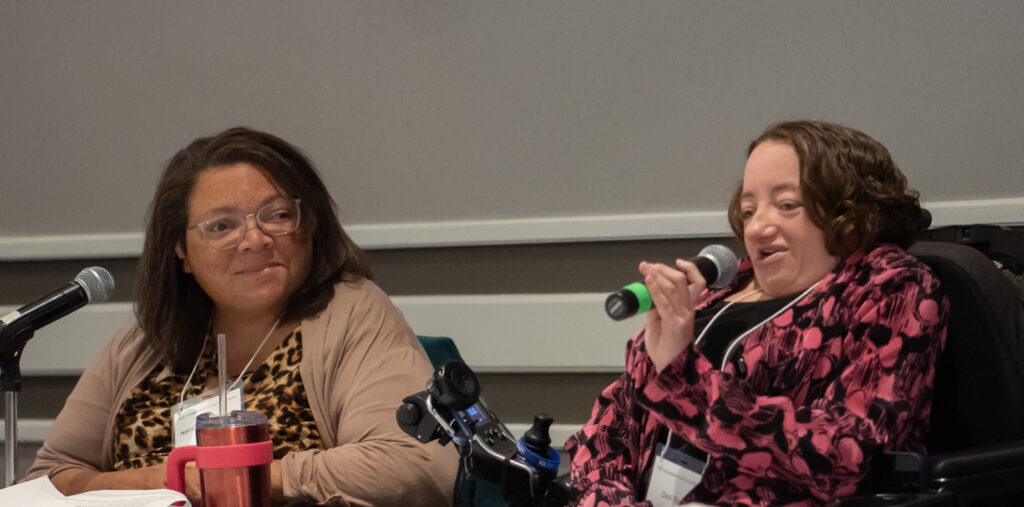 Hosts: Nancy Garr-Colzie and Desi Forte speaking with micropones and smiling